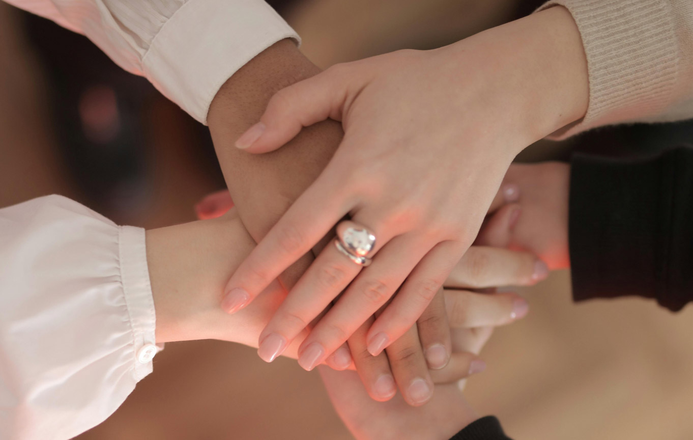 Týmové ruce položené na sobě na znamení spolupráce